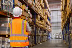 A Man looking at inventory in a warehouse