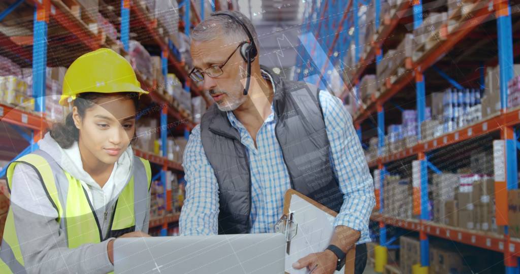 Two people looking at a computer on a laptop computer cart in warehouse