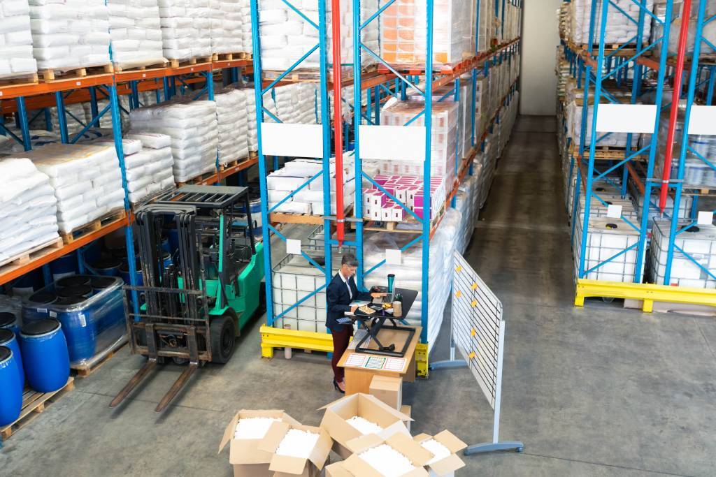 View from above of a man working at a standing desk in a warehouse