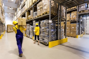 Warehouse worker with box and manager controlling products