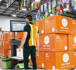 A warehouse worker standing next to a stack of boxes