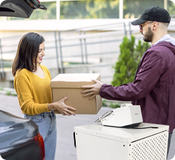 Retail worker assisting with curbside pickup using a mobile computer retail cart