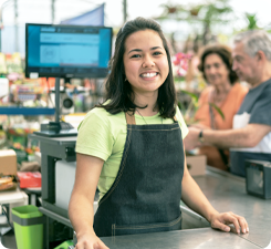 A retail worker smiling towards the camera